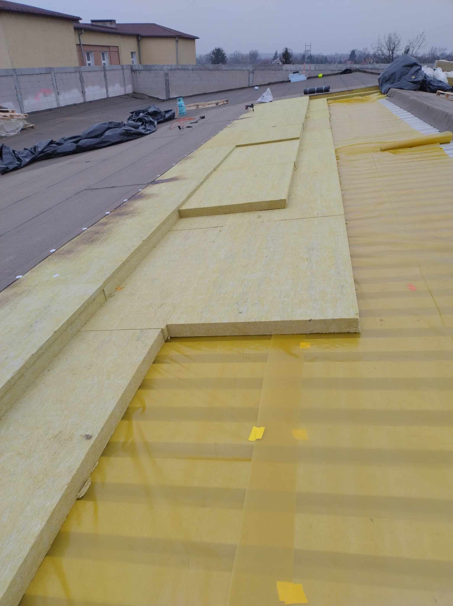 Montaż izolacji termicznej na dachu płaskim.